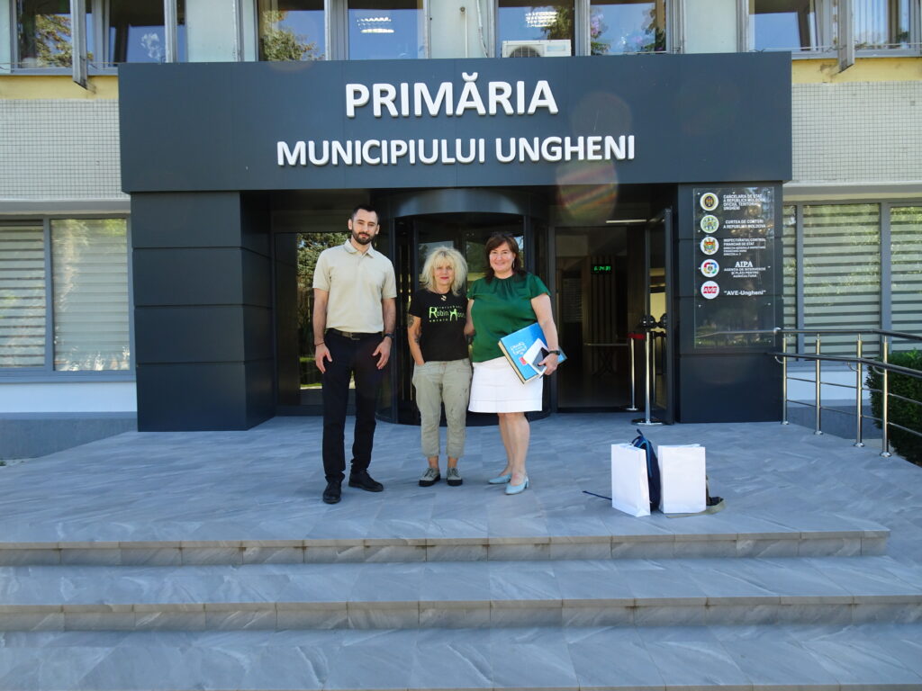 Marion vom Tierschutzverein Robin Hood mit dem Vizebürgermeister und einer weiteren Dame der Stadtverwaltung stehen gemeinsam vor dem Gebäude der Primaria in Ungheni, Moldau.